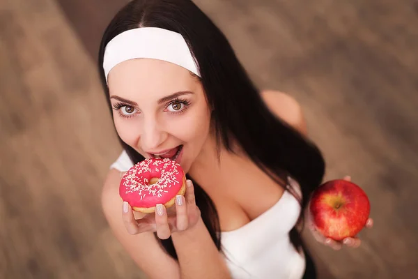 Retrato de una hermosa joven morena mostrando opciones de comida dietética . —  Fotos de Stock