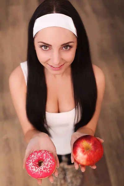 Portrait of a gorgeous young brunette woman showing diet food choices. — Stock Photo, Image