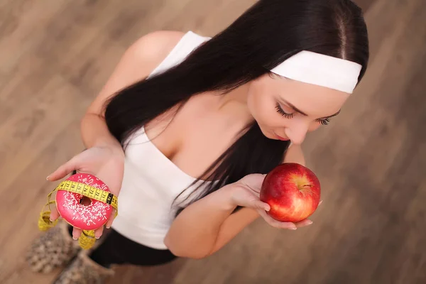 Retrato de una hermosa joven morena mostrando opciones de comida dietética . —  Fotos de Stock