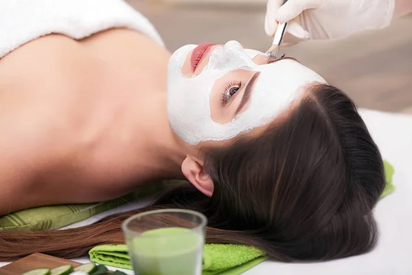 Spa concept. Handmatig aanbrengen van voedende masker op vrouwelijk gezicht in spa salon — Stockfoto