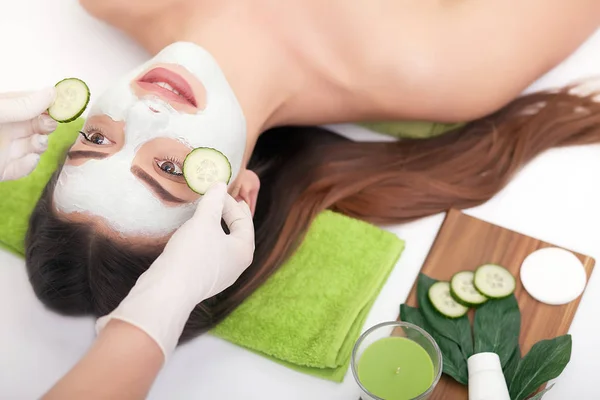 Gezichtsmasker vrouw gezicht toe te passen op een witte achtergrond — Stockfoto