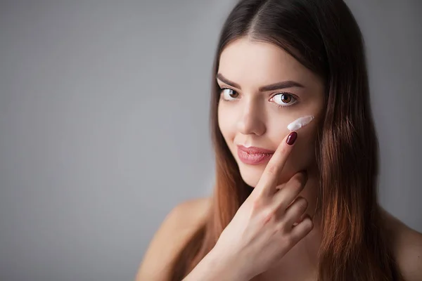 Beauty-Hautpflege. schöne glückliche Frau, die kosmetische Creme aufträgt — Stockfoto