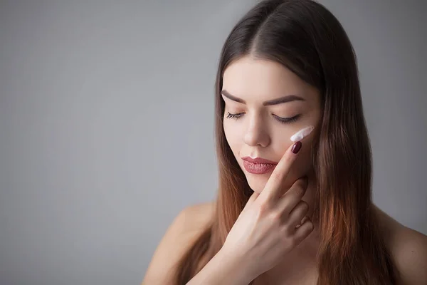 Beauty-Hautpflege. schöne glückliche Frau, die kosmetische Creme aufträgt — Stockfoto