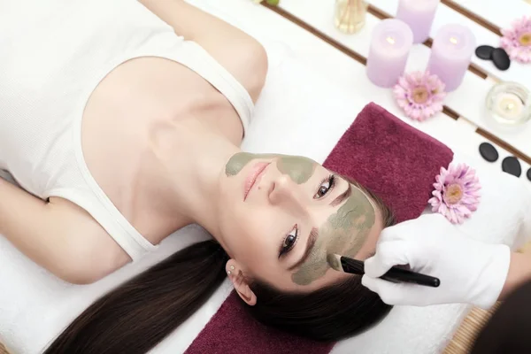 Spa behandling för ung kvinna som fick ansiktsmask på skönhet salo — Stockfoto