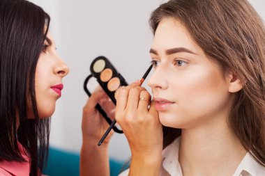 Kalıcı makyaj ana, resim dudaklar genç güzel modeli el. Makyaj devam ediyor