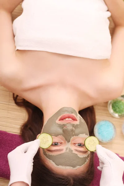 Spa. Care Facial. Funny young girl with a mask for skin face and cucumbers — Stock Photo, Image