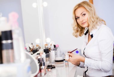 Makyaj sanatçısı araçları hazırlama ayna onun işyerinde başlamak için. Bekleyen müşteri. Güzellik Salonu.