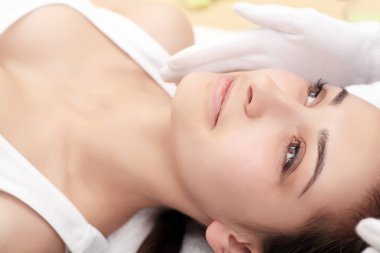Cilt ve vücut bakımı. Yakın çekim Spa muamele güzellik salonunda genç bir kadın. Spa yüz masaj. Yüz güzellik bakımı. Spa Salonu.