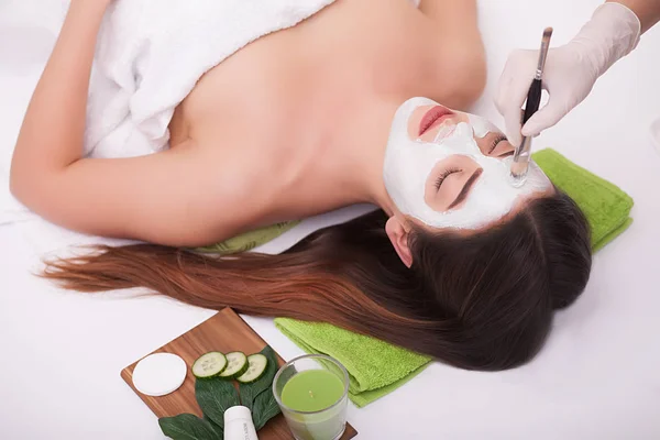 Jonge mooie vrouw met gezichtsmasker, spa behandeling — Stockfoto