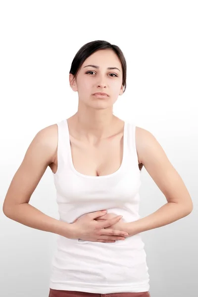 Problemas de salud. Hermosa mujer joven sintiendo dolor fuerte en el estómago. Mujer que sufre de sensación dolorosa, dolor de estómago, dolor abdominal, tener problemas de digestión. Concepto de Salud. Alta resolución — Foto de Stock