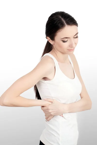 Dolor de espalda. Hermosa mujer joven sintiendo fuerte dolor de columna vertebral, tener problemas de salud. Muchacha atractiva que sufre de sensación dolorosa, dolor de espalda, sosteniendo las manos en el cuerpo. Concepto de Salud. Alta resolución — Foto de Stock