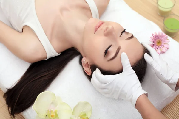 Pelle e cura del corpo. Primo piano di una giovane donna che riceve cure termali al salone di bellezza. Massaggio viso Spa. Trattamento di bellezza facciale. Salone Spa . — Foto Stock