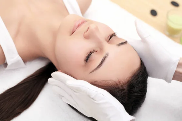 Cuidado de la piel y el cuerpo. Primer plano de una mujer joven recibiendo tratamiento de spa en el salón de belleza. Masaje facial spa. Tratamiento de belleza facial. Salón de Spa . — Foto de Stock