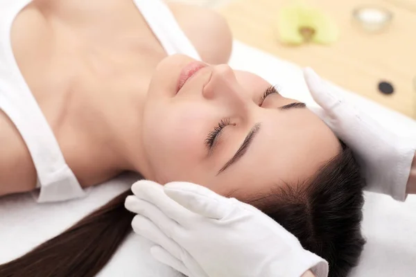 Piękna kobieta o masażu dla jej skóry na twarzy w gabinecie kosmetycznym - poziomy relaks — Zdjęcie stockowe