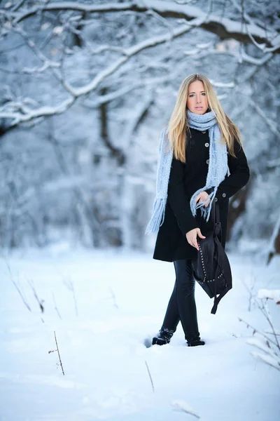 Menina loira jovem atraente andando na floresta de inverno. Mulher bonita no inverno ao ar livre. Vestindo roupas de inverno . — Fotografia de Stock