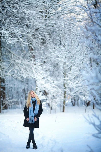 美丽的年轻女孩在街上微笑和散步。美丽的雪的寒冷的冬天。节日气氛. — 图库照片