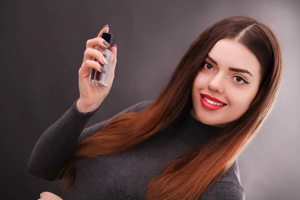 Junge lächelnde Frau versprüht Parfüm im Badezimmer — Stockfoto