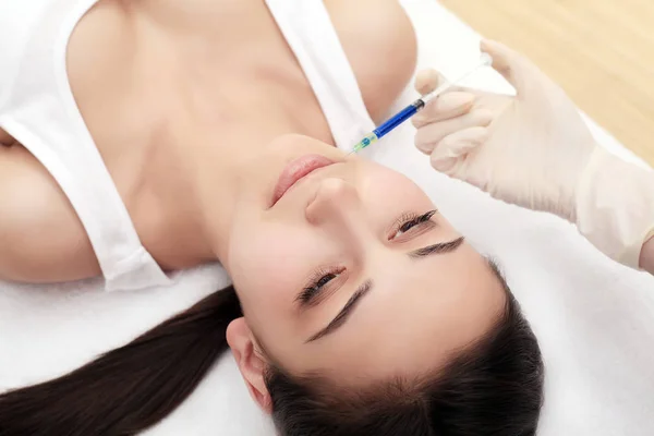 Mani di cosmetologo che fanno l'iniezione in faccia, labbra. Giovane wom — Foto Stock