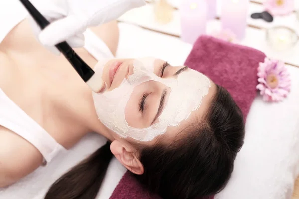 Kvinna med mask på hennes ansikte med huvudmassage. — Stockfoto