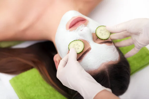 Spa concept. Hand applying nourishing mask on female face in spa salon — Stock Photo, Image