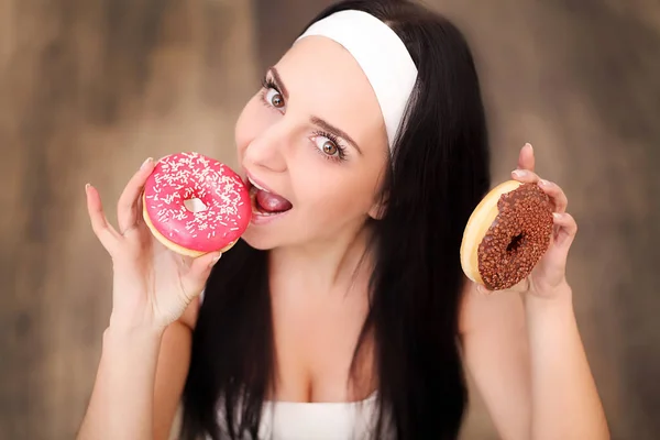 Young asian woman enjoy eating couple of sweet colorful donuts — Stock Photo, Image