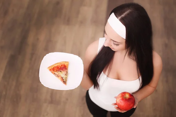 Vue rapprochée de la femme faisant le choix entre pomme et pizza esprit — Photo