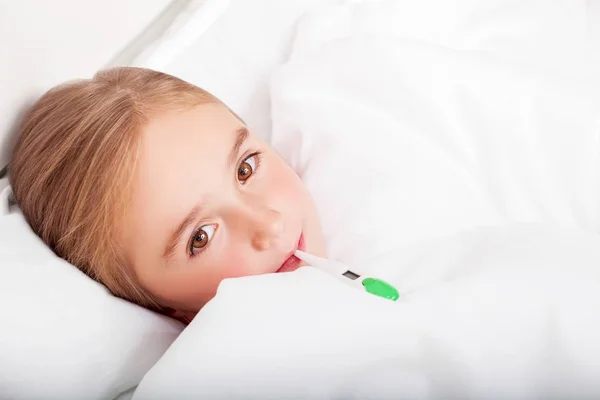 Grypy. Młoda dziewczyna leżąc w łóżku z termometrem — Zdjęcie stockowe