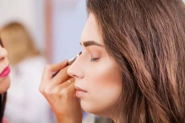 Maquillaje artista aplica sombra de ojos. Hermosa cara de mujer. Maquillaje perfecto — Foto de Stock