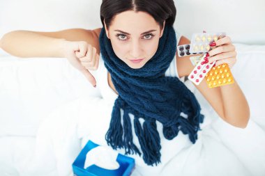 Yatakta yatarken ve tıp blister hapları tutan genç kadın