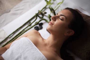 Güzel genç bir kadın güzellik salonunda yüz bakımı yaptırıyor..