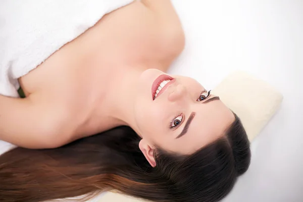 Schöne junge Frau entspannt sich mit Gesichtsmassage im Beauty-Spa — Stockfoto
