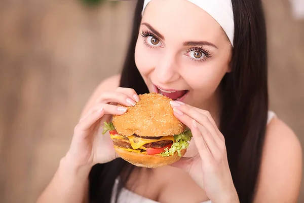 Jeune femme dans un restaurant gastronomique manger un hamburger, elle se comporte mal — Photo