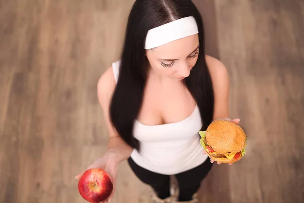 Jeune belle asiatique fille faire le choix entre hamburger et une pomme rouge, saine alimentation et mode de vie concept . — Photo