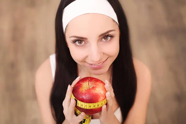 Belle femme tenant et mesurant pomme avec ruban à mesurer — Photo