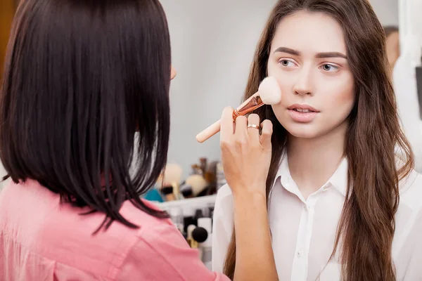 Make-up artist κάνει μακιγιάζ για ένα όμορφο κορίτσι στο σαλόνι ομορφιάς — Φωτογραφία Αρχείου