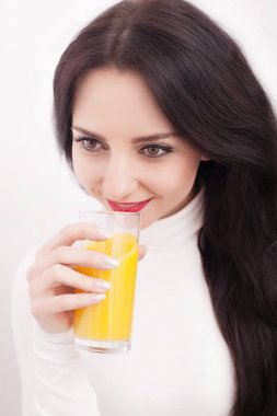 Beyaz zemin üzerine portakal suyu içme genç güzel kadın