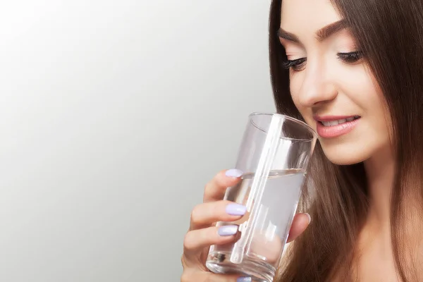 Bebe água. Feliz jovem bela mulher bebendo água. Um smili — Fotografia de Stock
