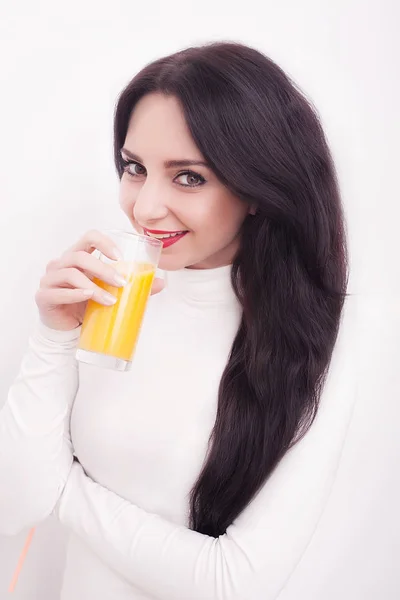 年轻美丽的妇女喝橙汁在白色背景 — 图库照片