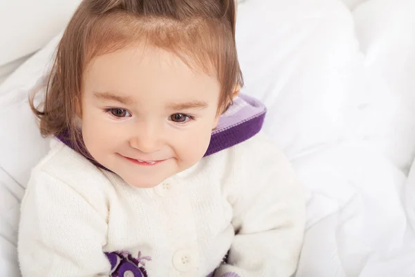 Bebê menina está escondido sob o cobertor branco — Fotografia de Stock