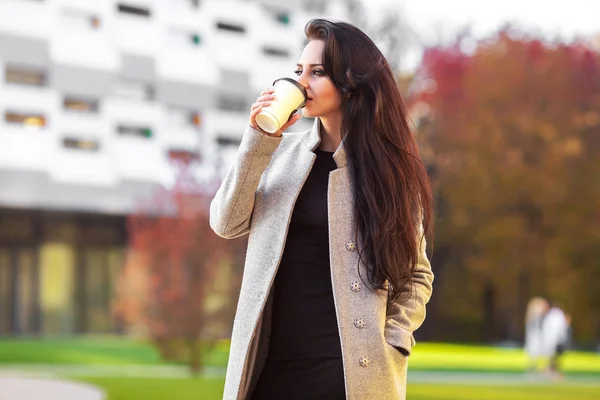 Schöne Frau hält Kaffeetasse aus Papier und genießt den Spaziergang i — Stockfoto