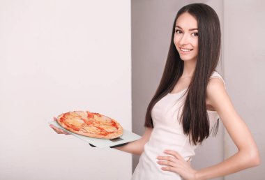 Diyet. Genç güzel kız pizza tutan ölçek ağırlığında. Con