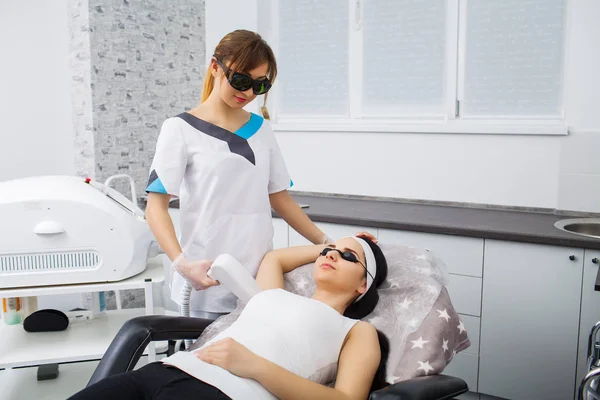 Laser epilation and cosmetology.at cosmetic beauty spa clinic. Hair removal cosmetology procedure from a therapist. Cosmetology and SPA concept. — Stock Photo, Image