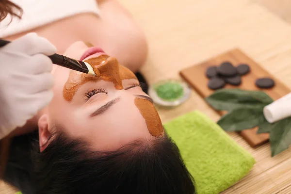 Concepto Spa. Mujer joven con nutriente mascarilla facial en salón de belleza, de cerca —  Fotos de Stock