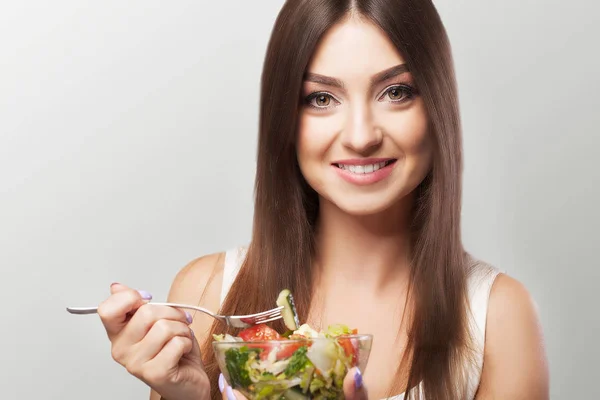 Retrato de una joven sonriente con sala de verduras vegetarianas — Foto de Stock