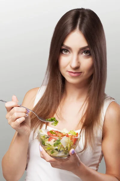 Retrato de una joven sonriente con sala de verduras vegetarianas — Foto de Stock