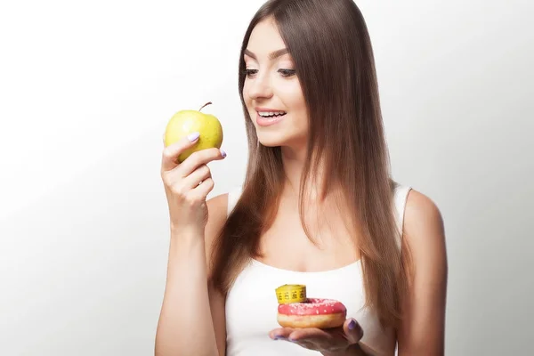 Une jeune femme fait un choix entre des aliments sains et nocifs. S — Photo