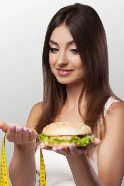 Dieta. Comida nociva e útil. Uma jovem faz uma escolha eithe — Fotografia de Stock