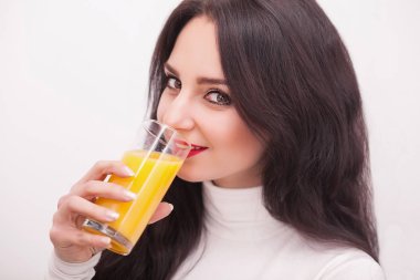 mutlu gülümseyen genç kadın portakal suyu içme