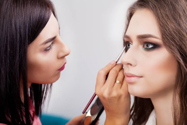Parlak temel rengi göz farı modelinin e üzerinde uygulama makyaj sanatçısı