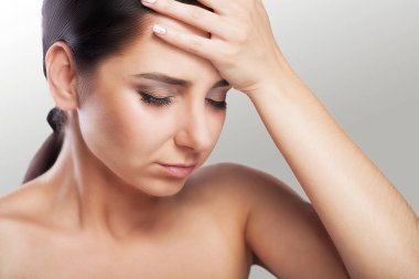 Çıplak bir omuz ile güzel bir genç esmer portresi hissediyor büyük baş ağrısı, sağlık sorunları, Migren, profesyonel makyaj.